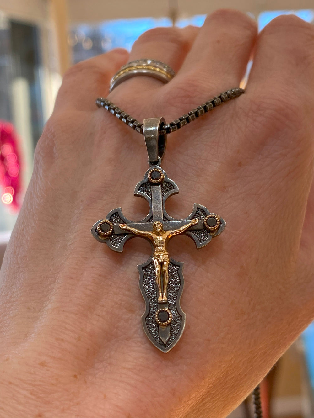 Sterling silver and 14K gold crucifix pendant with black diamonds shown on model