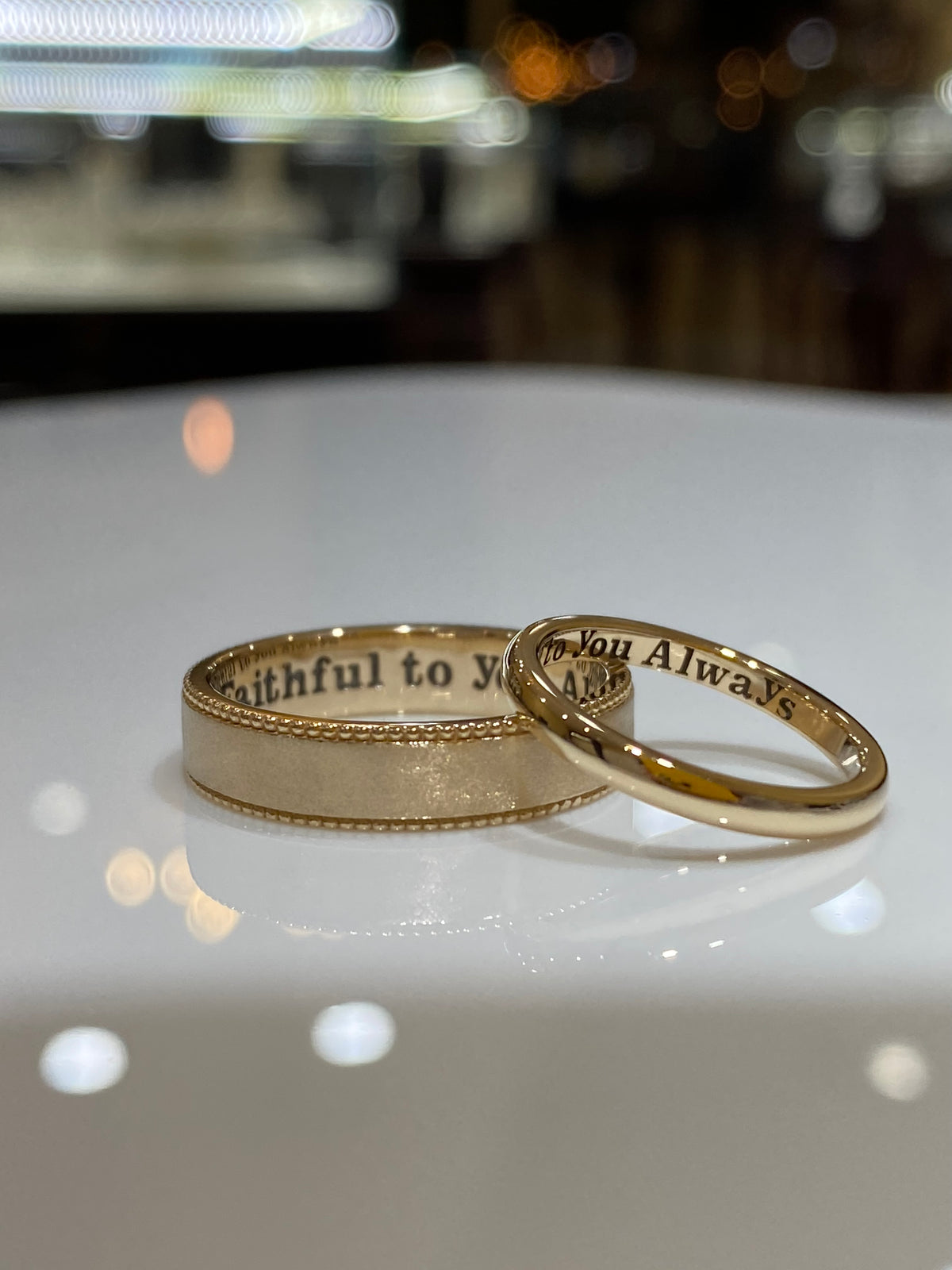 Two finished yellow-gold wedding bands with personal engravings inside