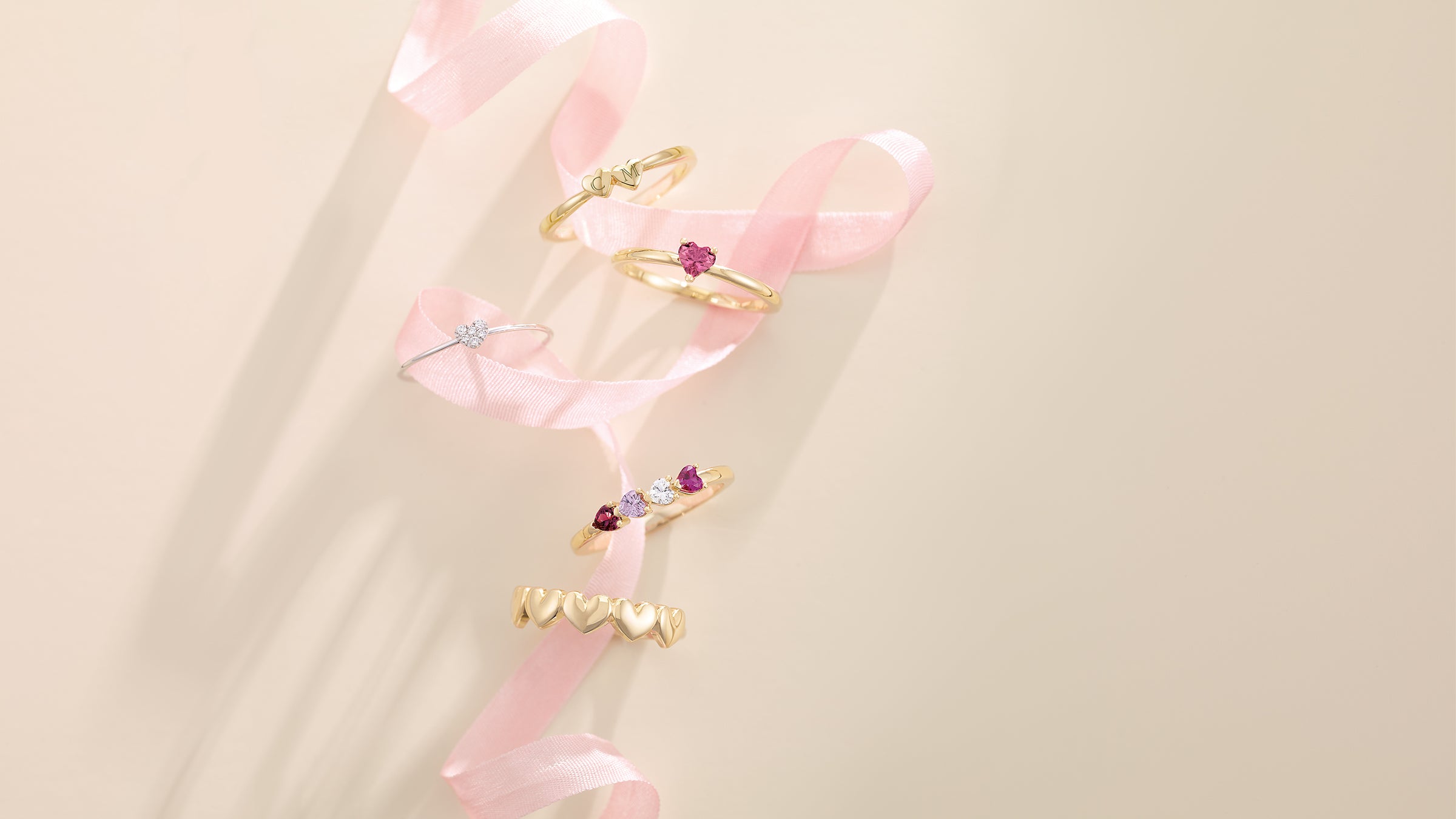 Handcrafted diamond and gold rings from Couture Jewelry NYC displayed against soft neutral fabric background.