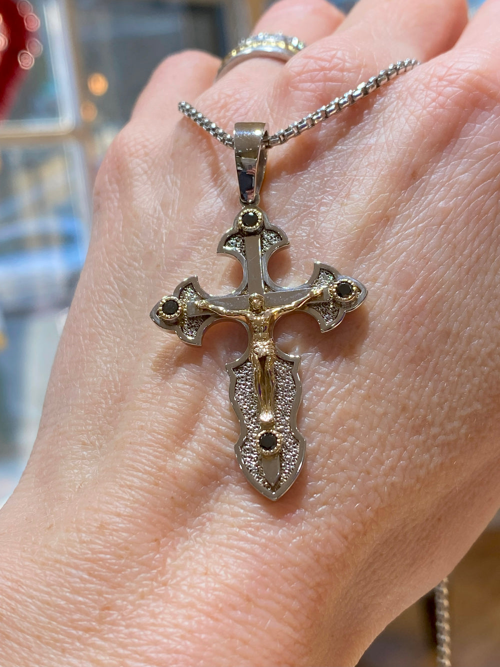 14K yellow and white gold crucifix pendant with black diamonds shown on model