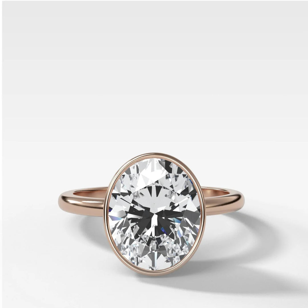 14k rose gold oval diamond bezel engagement ring, showing warm pink gold tone and secure setting