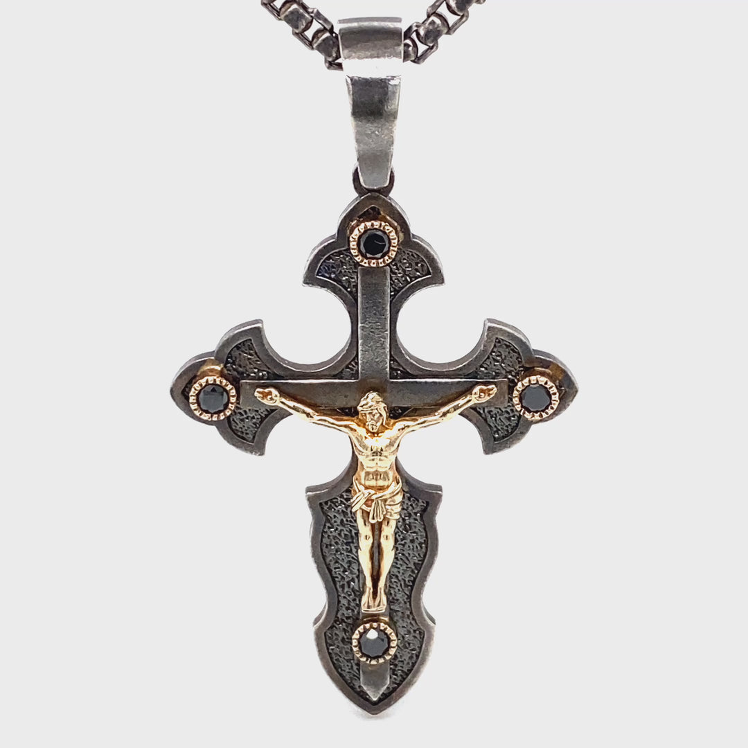 Side view of sterling silver and 14K yellow gold crucifix pendant with black diamond accents