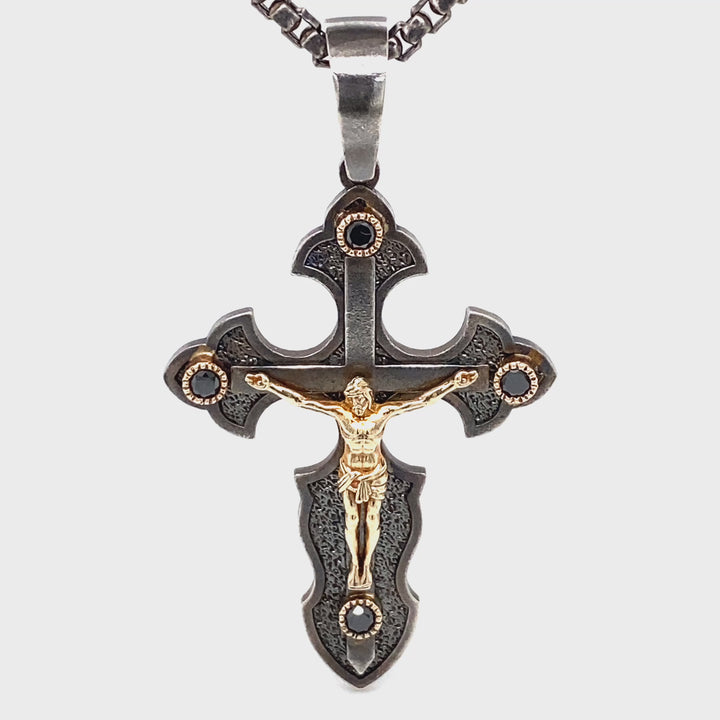 Side view of sterling silver and 14K yellow gold crucifix pendant with black diamond accents