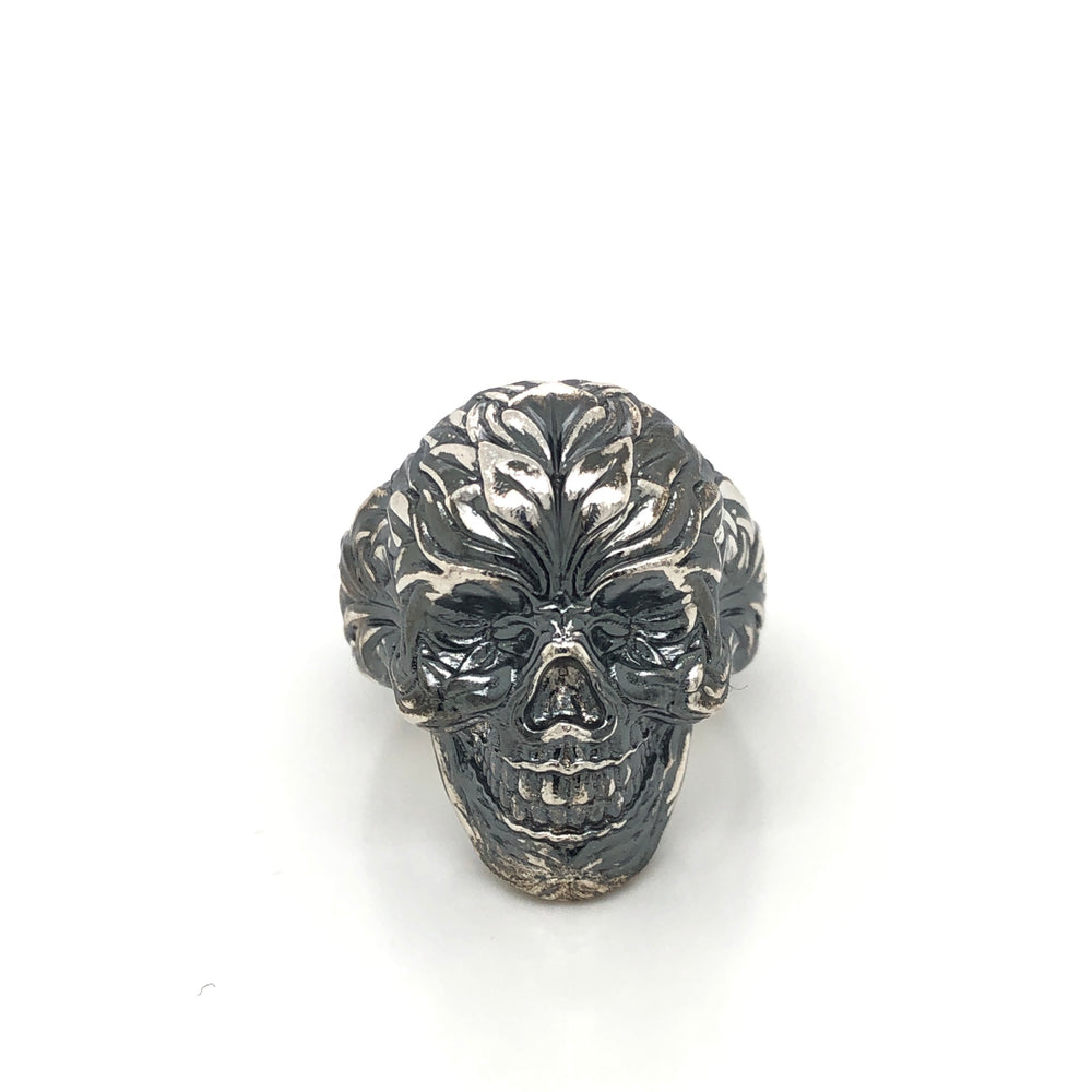 Detail view of oxidized silver skull ring showing intricate side engravings