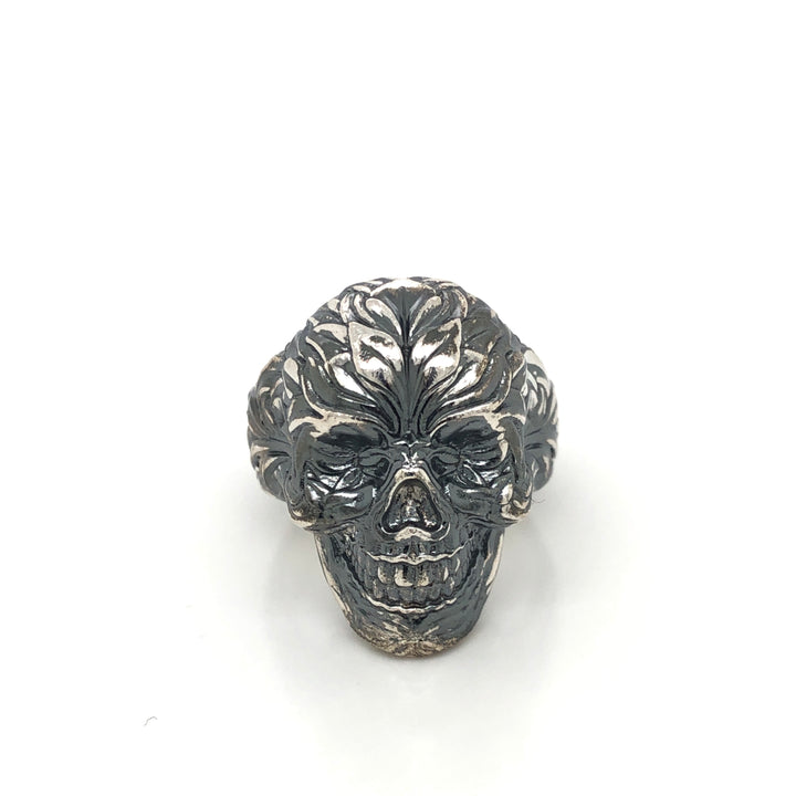 Detail view of oxidized silver skull ring showing intricate side engravings